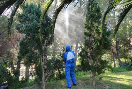 Illes control fent tasques de fumigació contra plagues de jardí